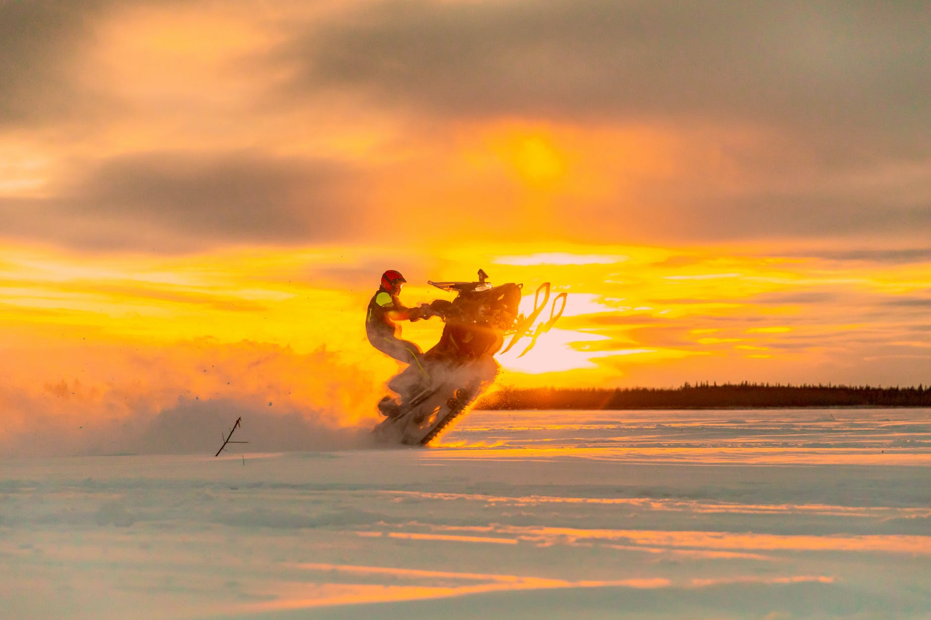 man performing stunt on snowmobile